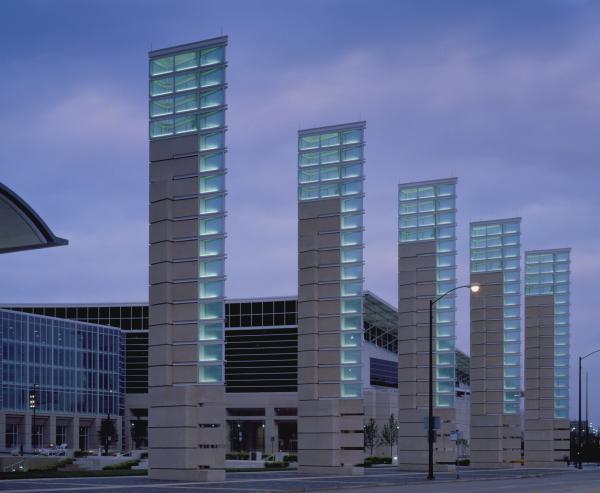 Large concrete and glass sculptures in the foreground. In the background is a convention center