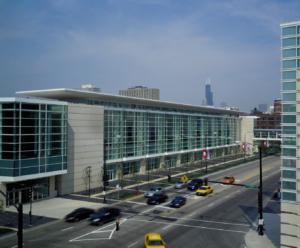 Large convention center exterior with concrete and huge glass window in an urban setting