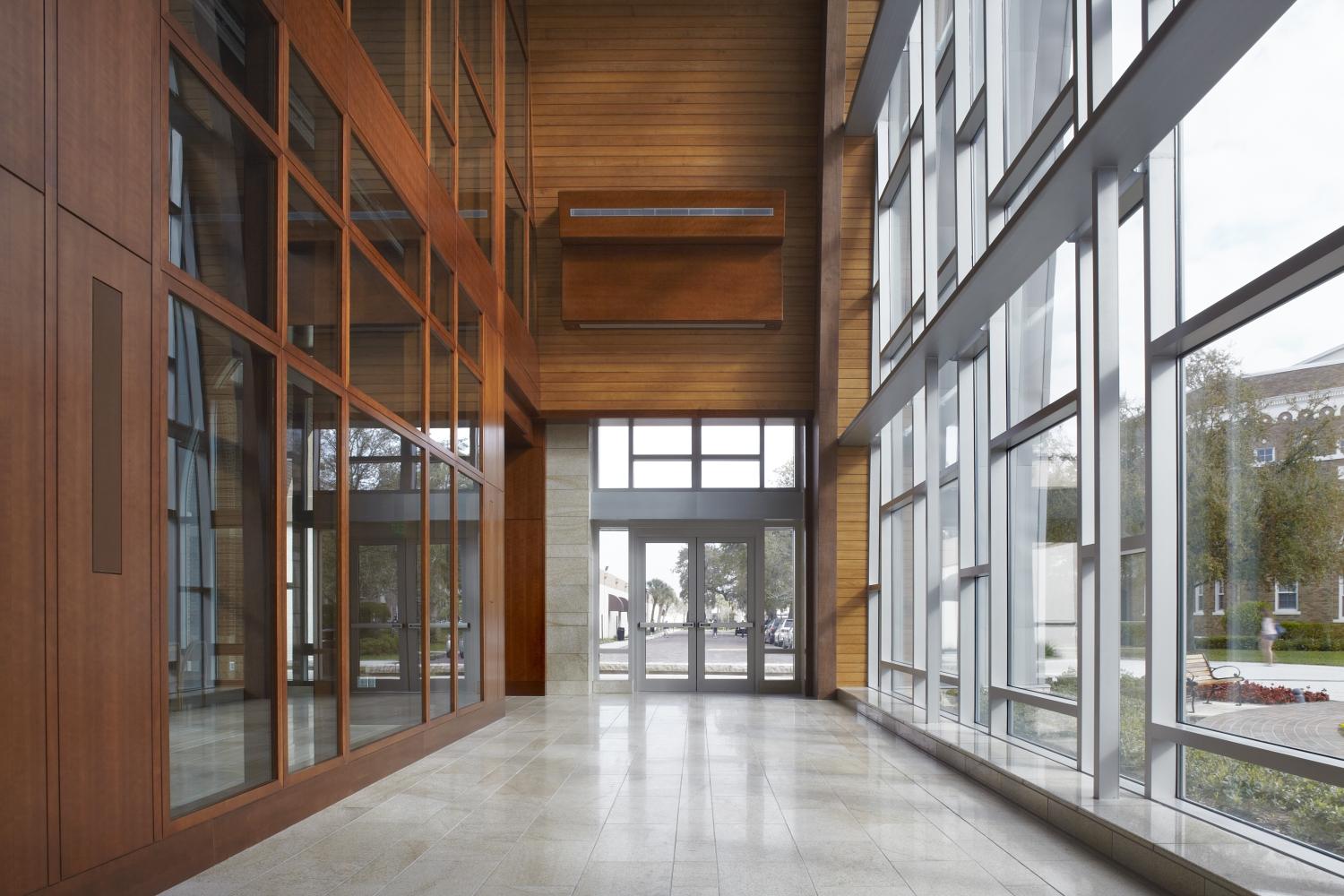 a hallway with glass walls and a wood ceiling