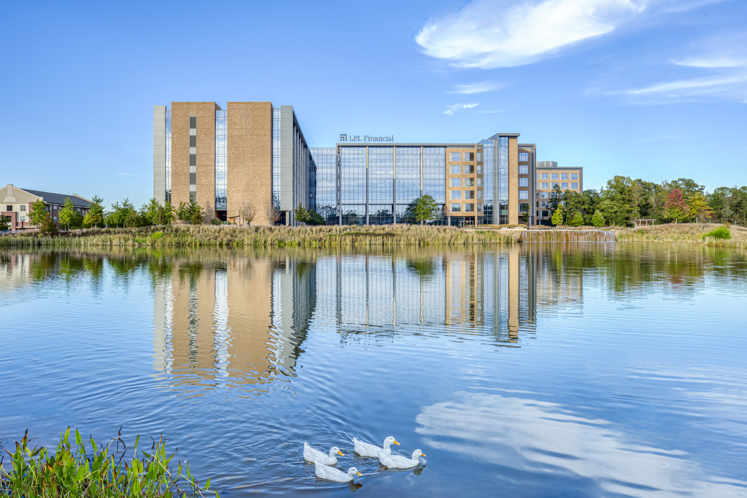 A corporate campus with 2 large office buildings in front of a lake