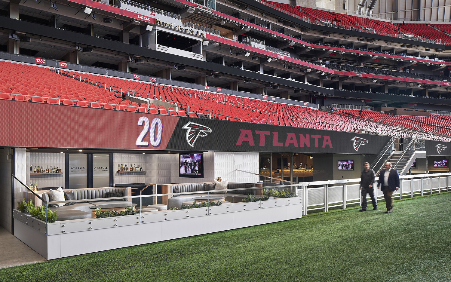 Two people walk in front of the Delta Sky Terrace at Mercedes-Benz Stadium